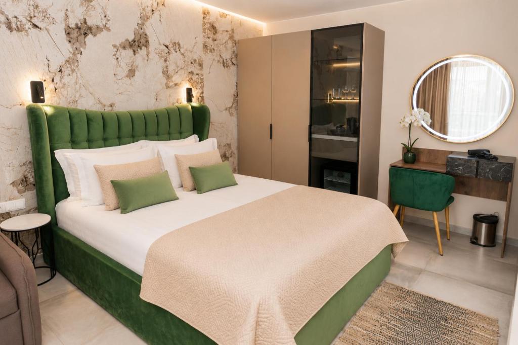 a bedroom with a large bed with a green headboard at Hotel Central in Sunny Beach