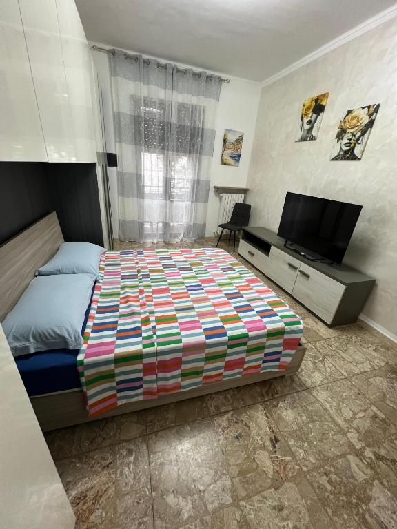 a bedroom with a bed and a flat screen tv at Relax suite in Alessandria