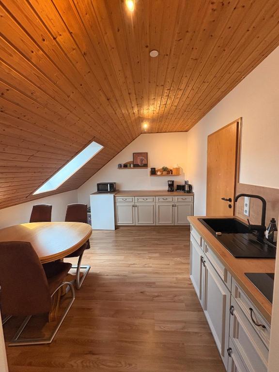 a kitchen with a wooden ceiling and a wooden table at Ferienwohnung am Feistelholz in Wernberg-Köblitz