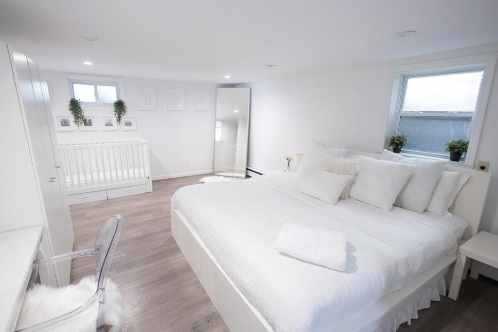 a white bedroom with a large white bed with white pillows at Minimal 1bed APT basement with free parking in Yonkers