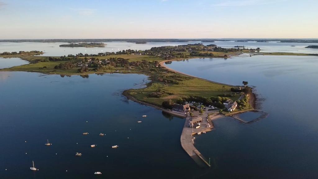 an island in a large body of water with boats at Hôtel Restaurant L'Escale d'en Arz in Ile d'Arz