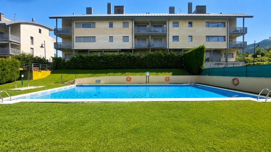 an empty swimming pool in front of a building at Las Xanas · Vistas, Piscina y Terraza en LLanes in Llanes