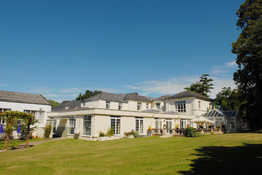 a large white house with a large yard at Oriel Hotel in St Asaph