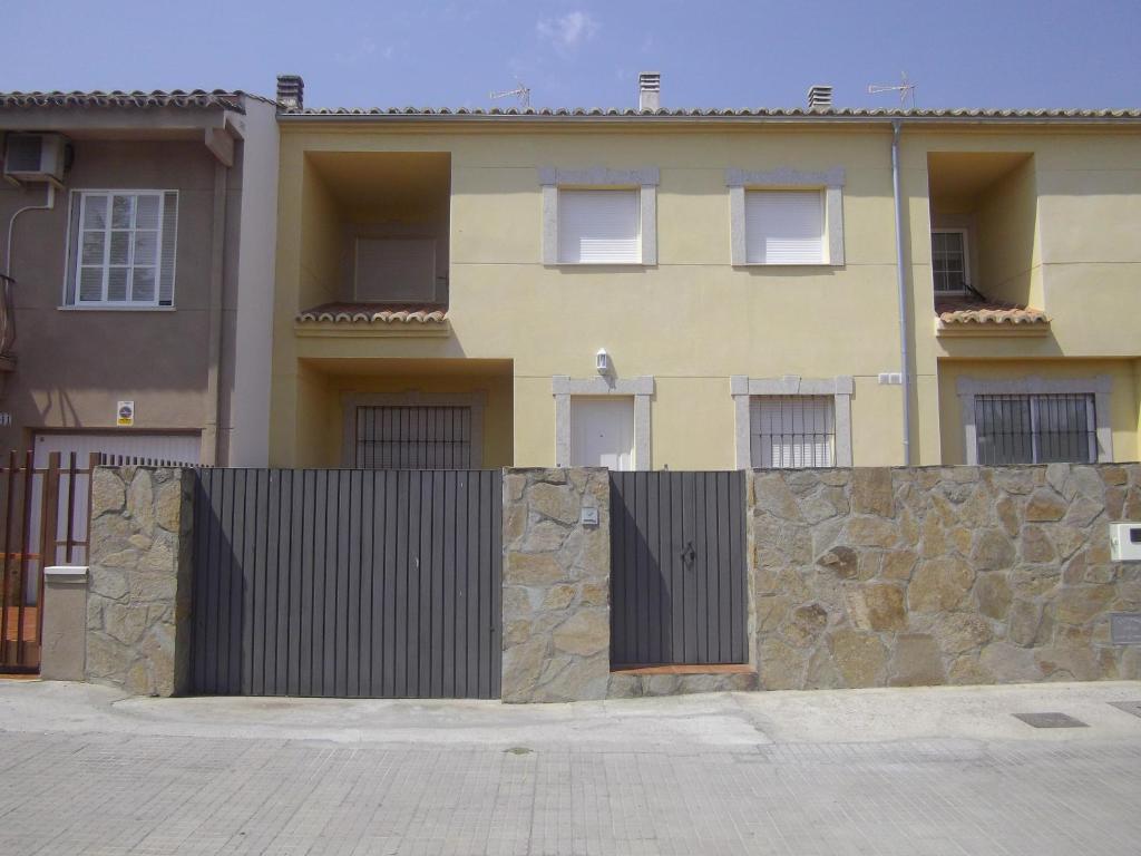 una valla frente a una casa con un edificio en Apartamento Villa Soterraña, en Trujillo