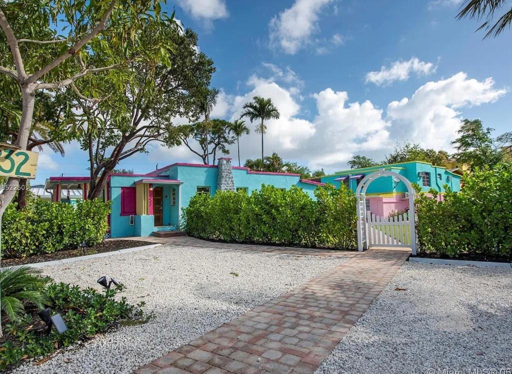 a gate in front of a colorful house at Coastal Bungalows--The Flamingo Bungalow in Fort Lauderdale