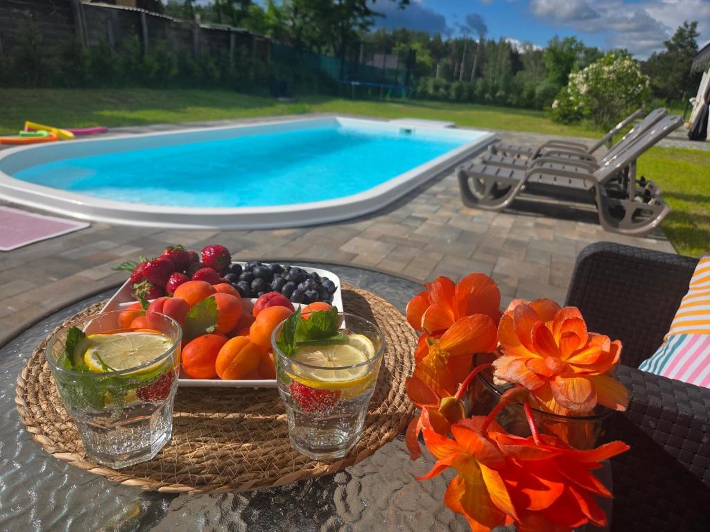 a tray of fruit on a table next to a swimming pool at Emville in Vysshaya Dubechnya