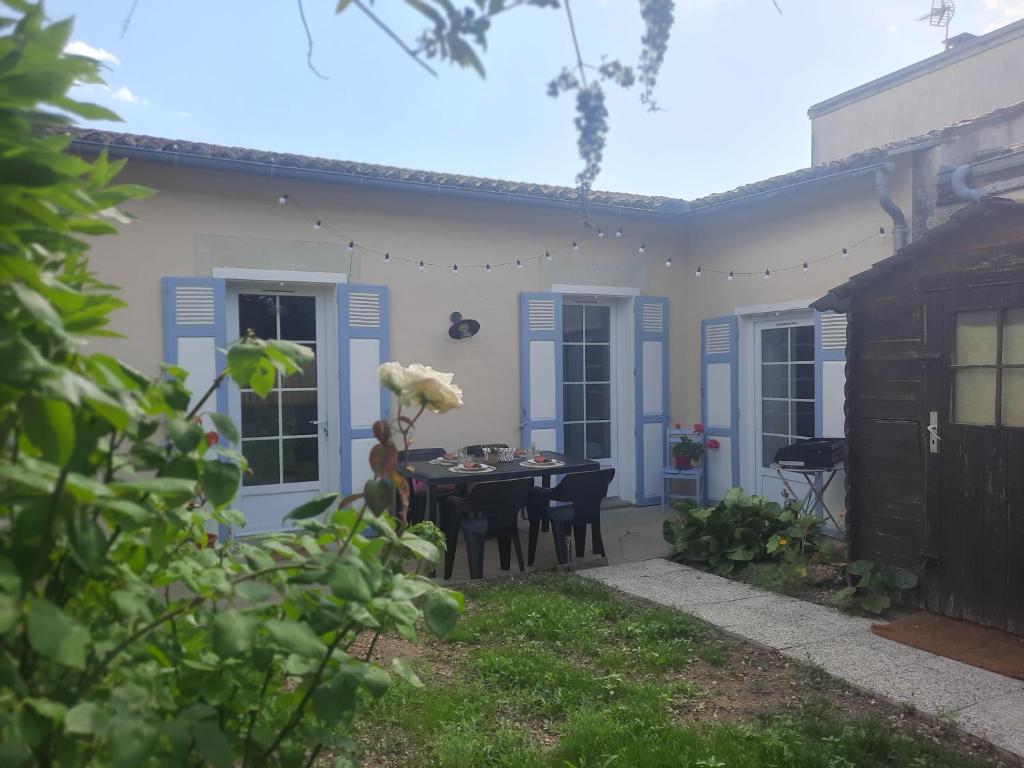 a house with a table and chairs in the yard at Le Gite Boho in Vendeuvre-du-Poitou