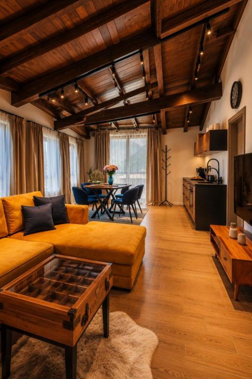 a living room with a couch and a table at Къща за гости Domus Harmonia - Jacuzzi & BBQ near Bansko in Banya