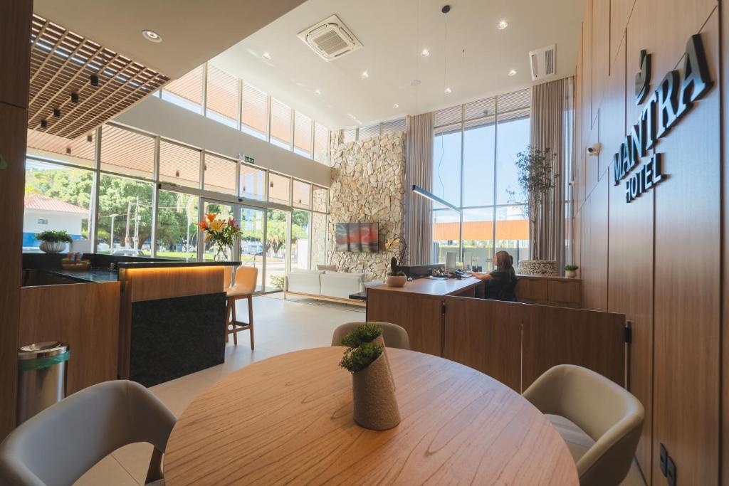 a lobby with a table and chairs and a counter at Mantra Hotel in Feliz Natal