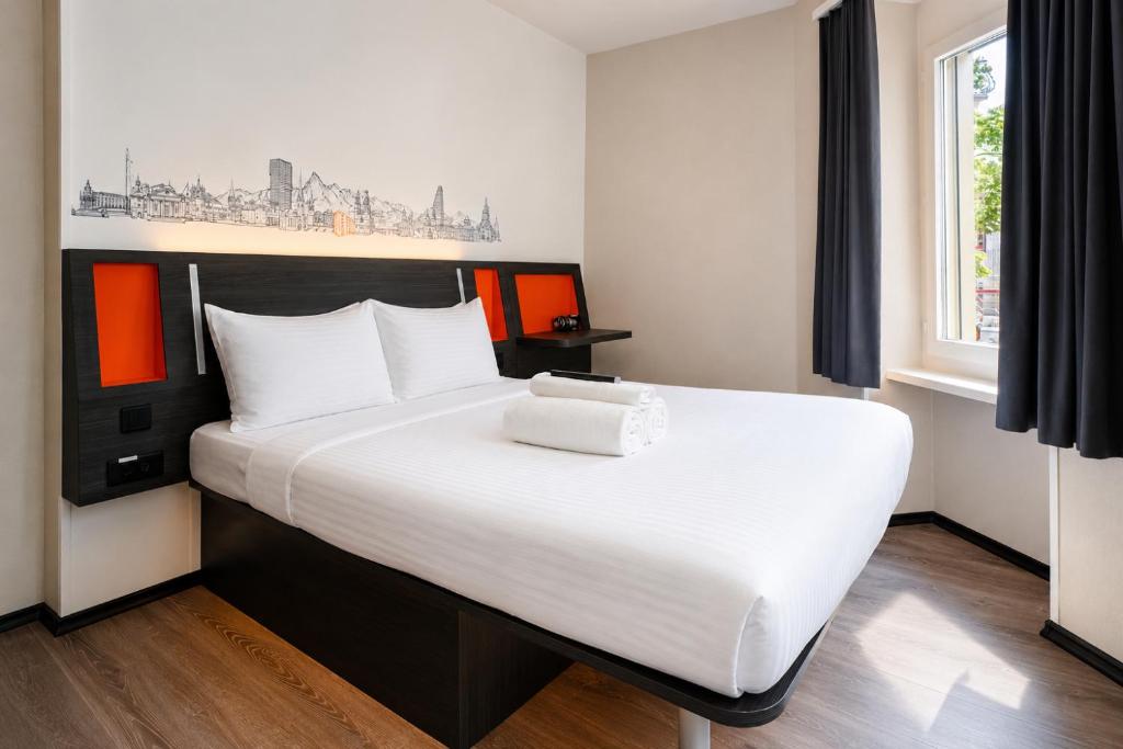 a bedroom with a large bed with white sheets at easyHotel Zürich City Main Station in Zurich