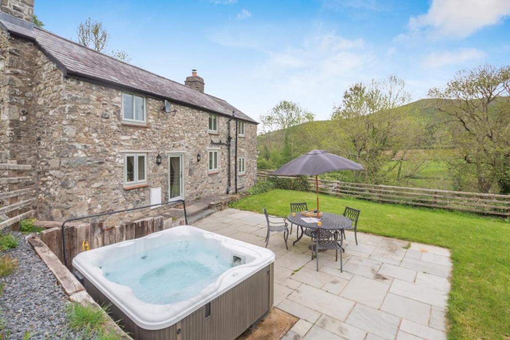 a bath tub on a patio in front of a house at 2 Bed in Abergele oc-88974 in Llanfair Talhaiarn