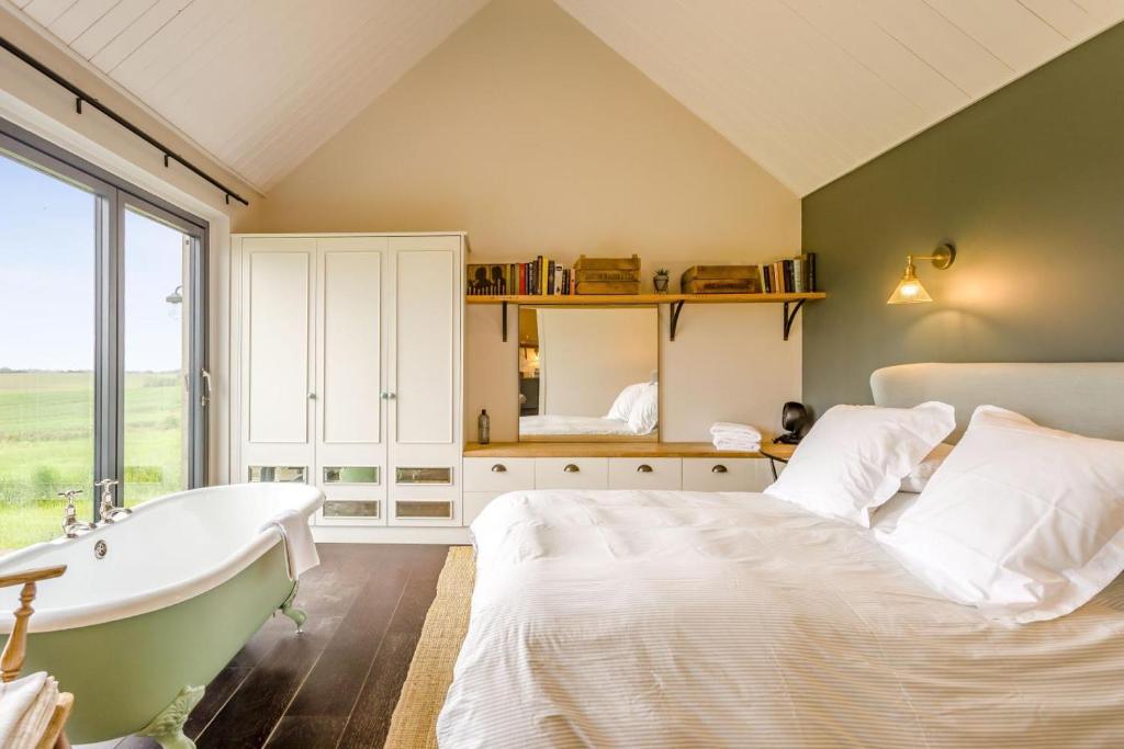 a bedroom with a bed and a bath tub at 1 Bed in Wickhambrook oc-tosh in Wickhambrook