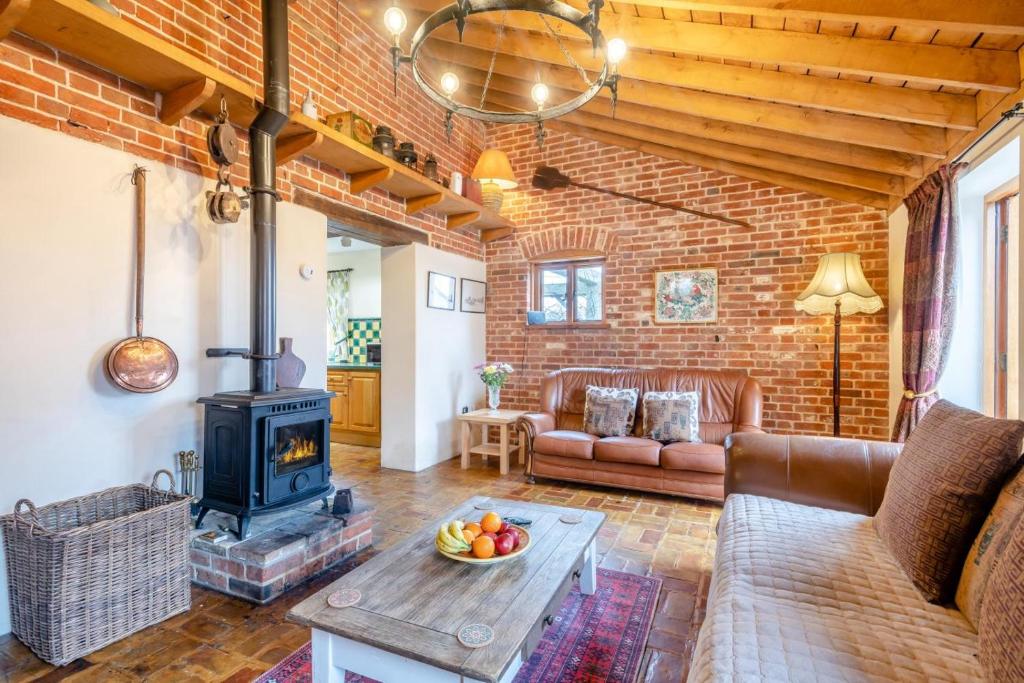 a living room with a brick wall and a wood stove at 6 Bed in Wangford oc-e31107 in Wangford
