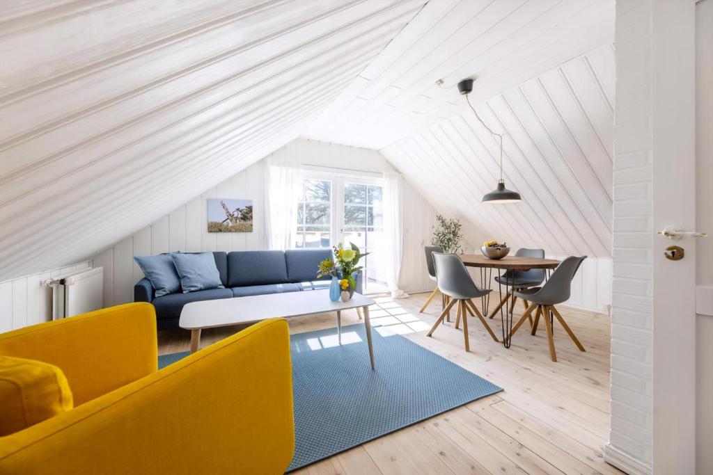 a living room with a blue couch and a table at Høloftet - Charming Vacation Apartment On The 1St Floor Of Hawbakken in Hjørring