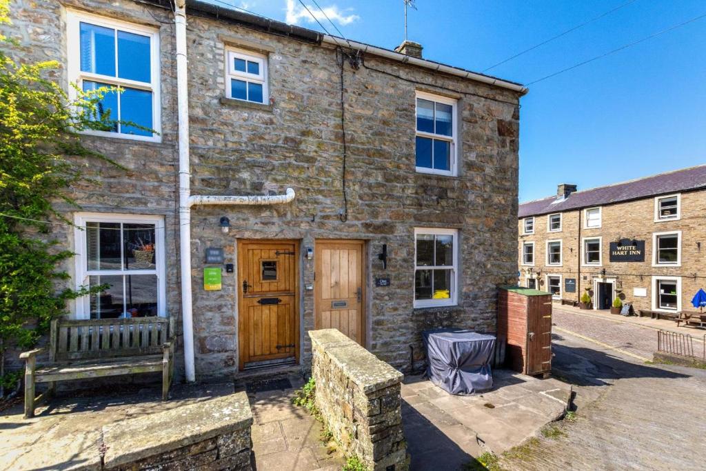 a brick building with a wooden door and a bench at 2 Bed in Hawes oc-ds042a in Hawes