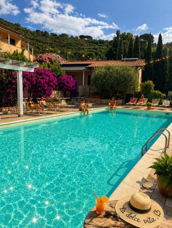 a swimming pool with people in a resort at Residence Le Solane in Marina di Campo