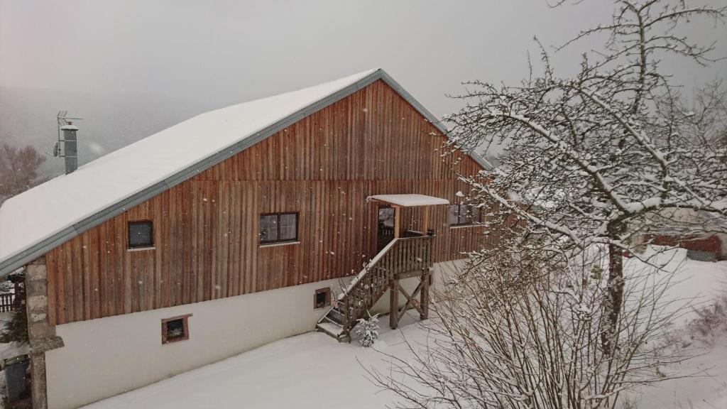 une grande grange en bois avec un toit enneigé dans l'établissement Le Solé Bassurois, à Basse-sur-le-Rupt