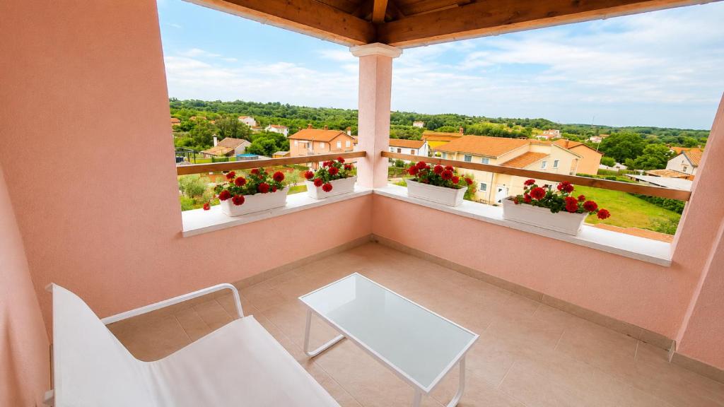 a balcony with a white table and chairs and flowers at Villa Rosa dei Venti in Kaštel
