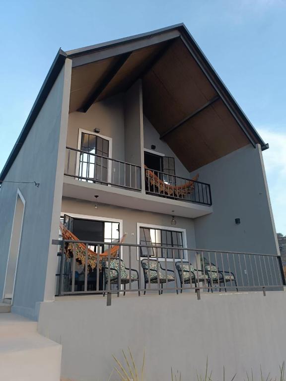 a building with chairs and tables on a balcony at Chalé Punaras in Araruna