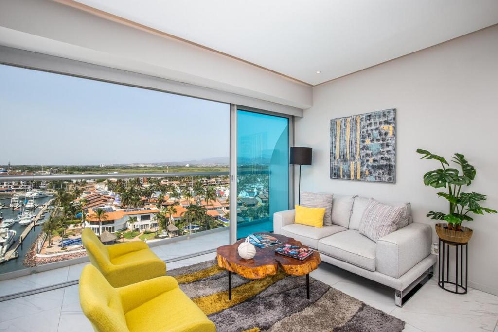 a living room with a couch and chairs and a large window at Nautico nautico 8a in Puerto Vallarta