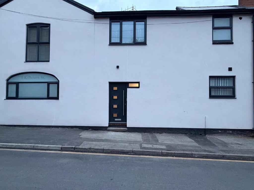 a white building with a door on the side of a street at 6 En-Suites with 7 Beds Near Arena & City in Nottingham