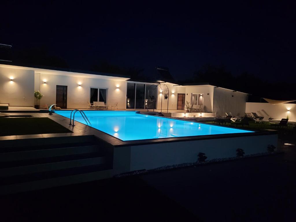 a swimming pool lit up at night at Diamona apartment lux sa pogledom na bazen in Donja Toponica