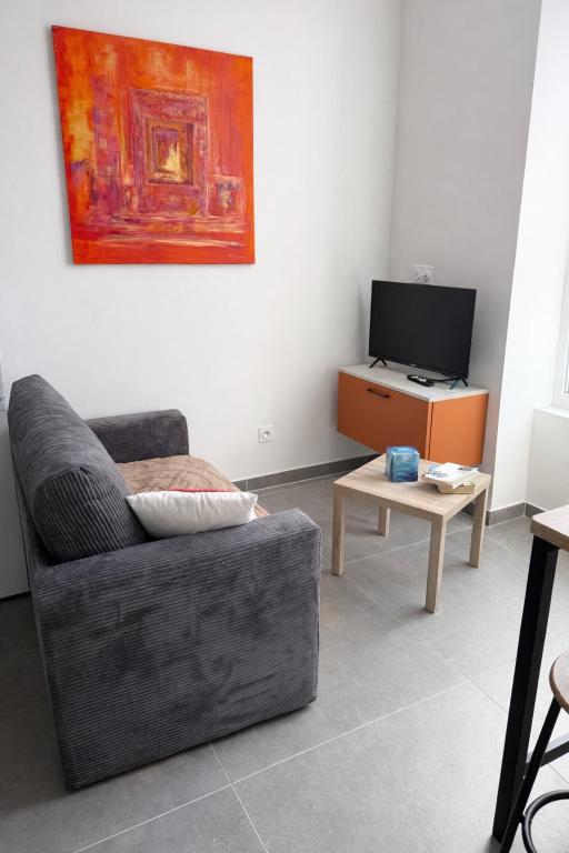 a living room with a couch and a table at 104 - centre de voiron - DeTassigny in Voiron