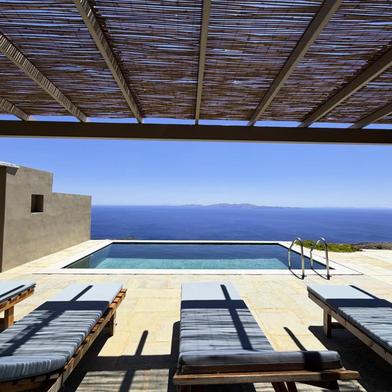 a swimming pool with a view of the ocean at Olea Tinos, A Luxury Villa in Kardhianí
