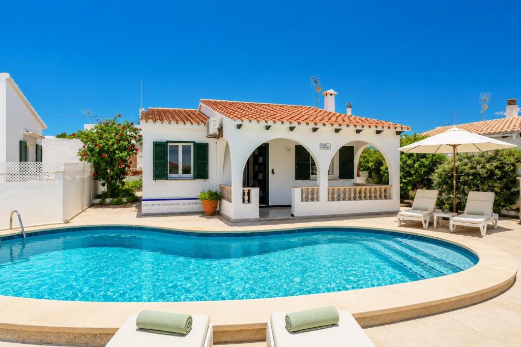 a villa with a swimming pool and a house at Villa Emilio in Cala en Porter