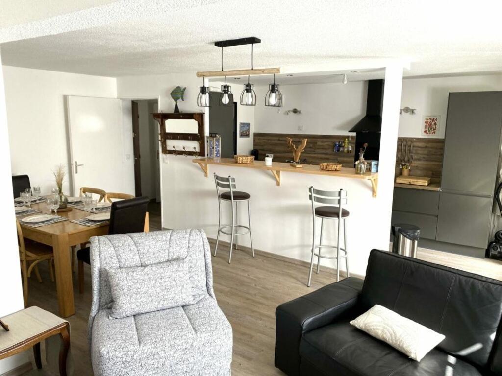 a living room with a couch and a table and a kitchen at Appartement Cool Montagne in Briançon