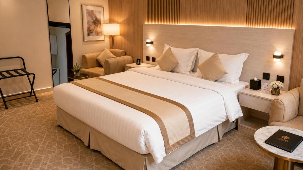 a hotel room with a large bed and a couch at دار السناء للشقق المخدومة Dar Al Sanaa Serviced Apartments in Jeddah