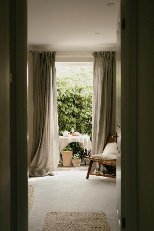 a room with a window with a table and a chair at Central Village Cottage, The Corders in Moreton in Marsh