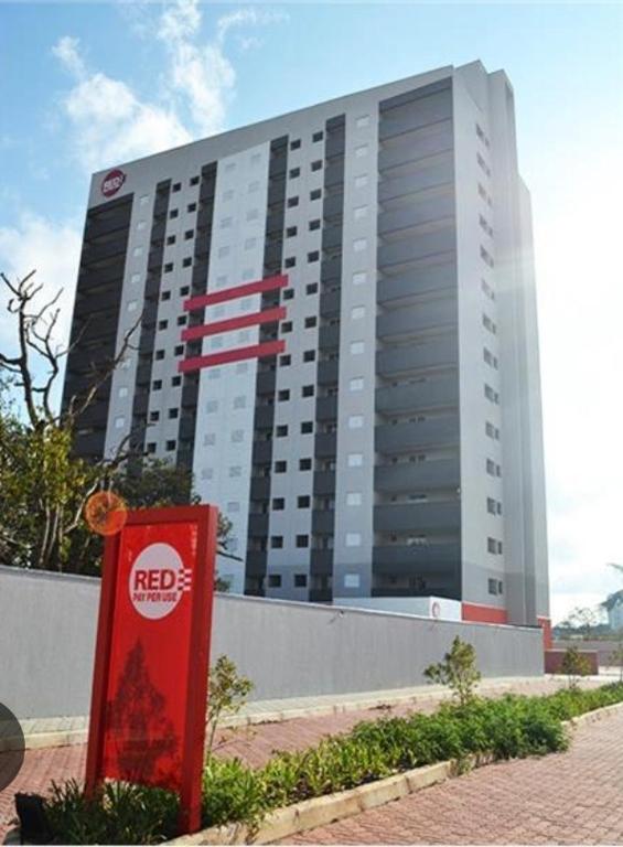 a large building with a red box in front of it at Flat 203 Red Sorocaba in Sorocaba