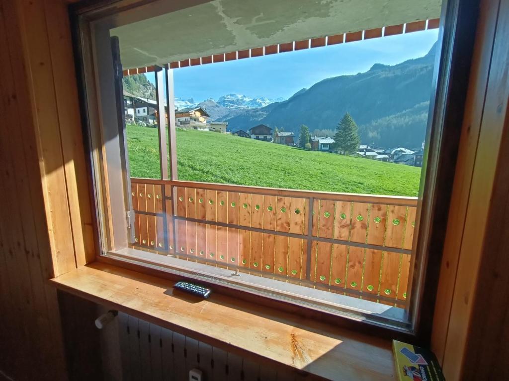 a window with a view of a fence and a field at Le Rondinelle in Champoluc