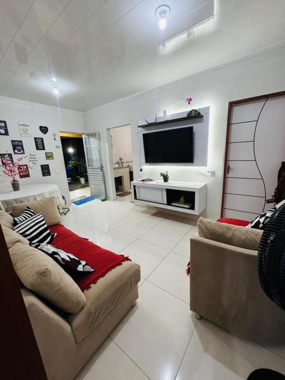 a living room with a couch and a flat screen tv at Meu aconchego in Castanhal