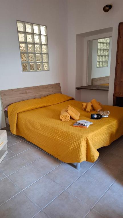 a bed in a room with a yellow blanket on it at Casal Baratz in Santa Maria la Palma