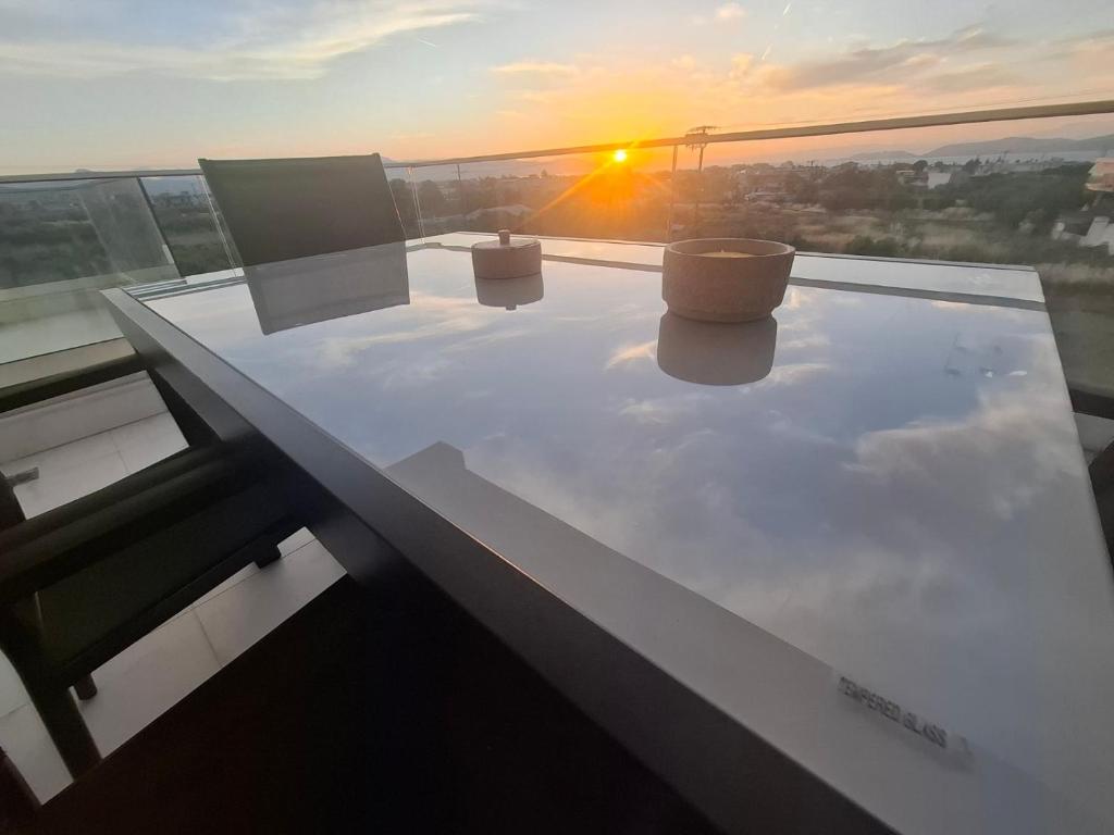 a table with two chairs on top of a building with the sunset at Hanna's Villagio in Korinthos
