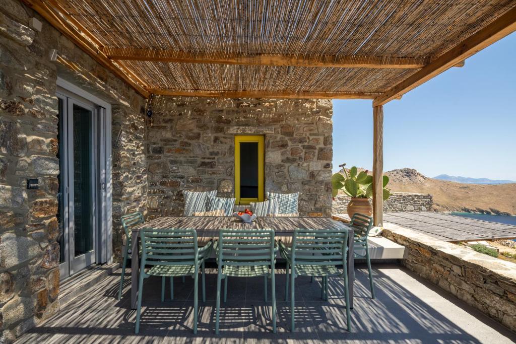 a patio with a table and chairs on a deck at Serene Shore Serifos in Alona
