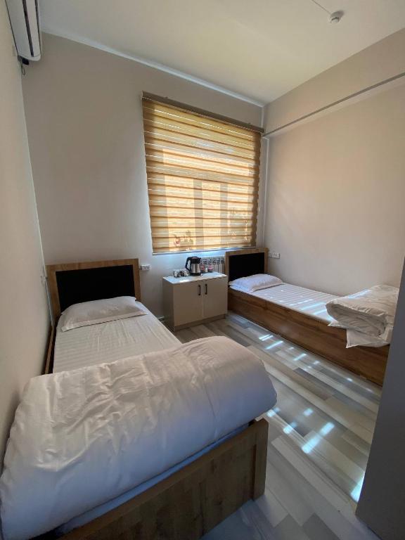 a room with two beds and a window in it at Pure Hostel in Tashkent