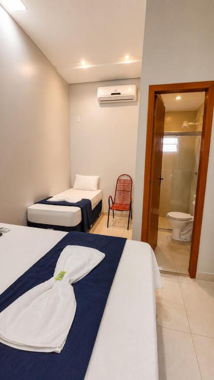 a hotel room with two beds and a toilet at Quarto suíte 8, cama casal1, cama solteiro 1 in Marabá
