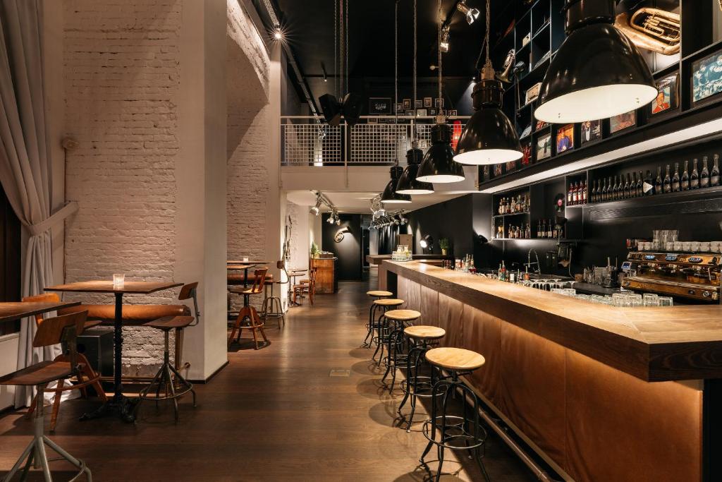a restaurant with a bar with stools and tables at Ruby Sofie Hotel Vienna by IHG in Vienna