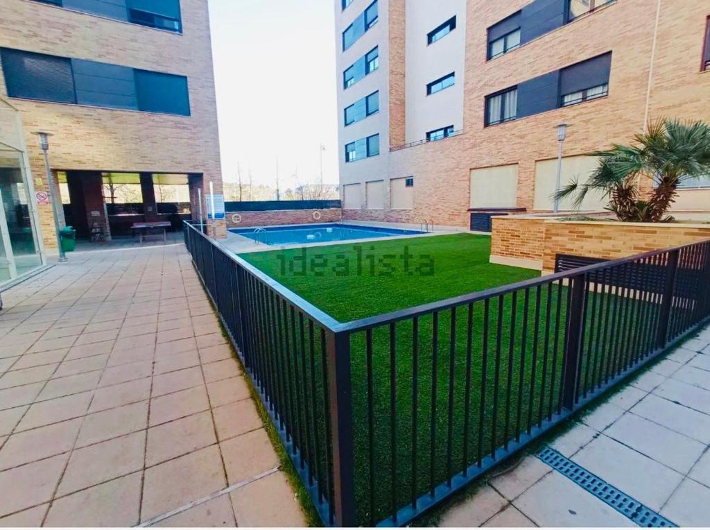 a swimming pool in front of a building at Ático La Puerta de Logroño, con terraza y piscina! in Logroño