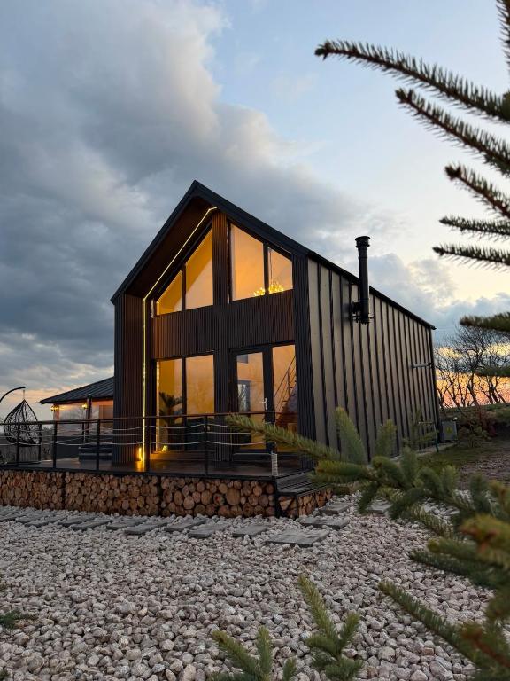 ein Haus mit großen Glasfenstern am Strand in der Unterkunft EleS Chalet in Brebu