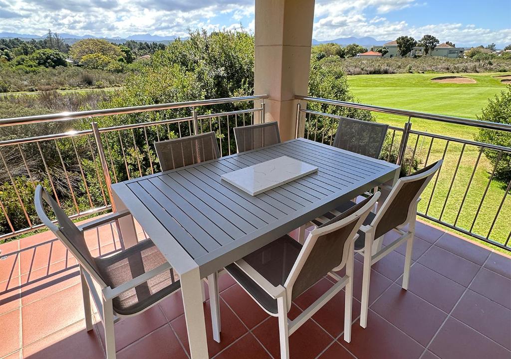 a blue table and chairs on a balcony at The Fairway Apartment in Plettenberg Bay