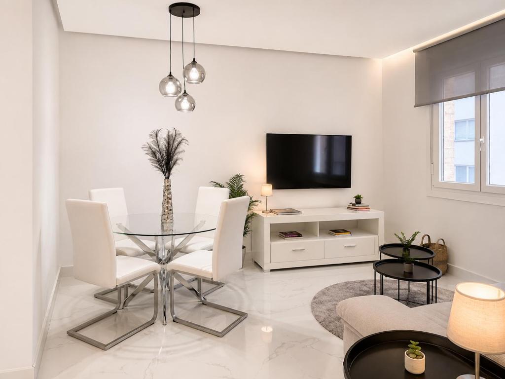 a white living room with a glass table and white chairs at Holibai Antia Mare Centro de Baiona y mar in Baiona