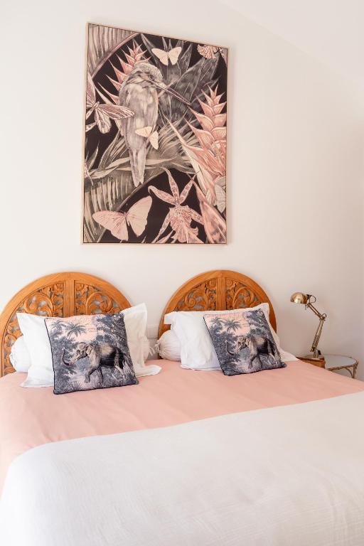 a bedroom with a bed with a picture on the wall at Lagoa Beach House B&B - Breakfast included in Serra do Bouro