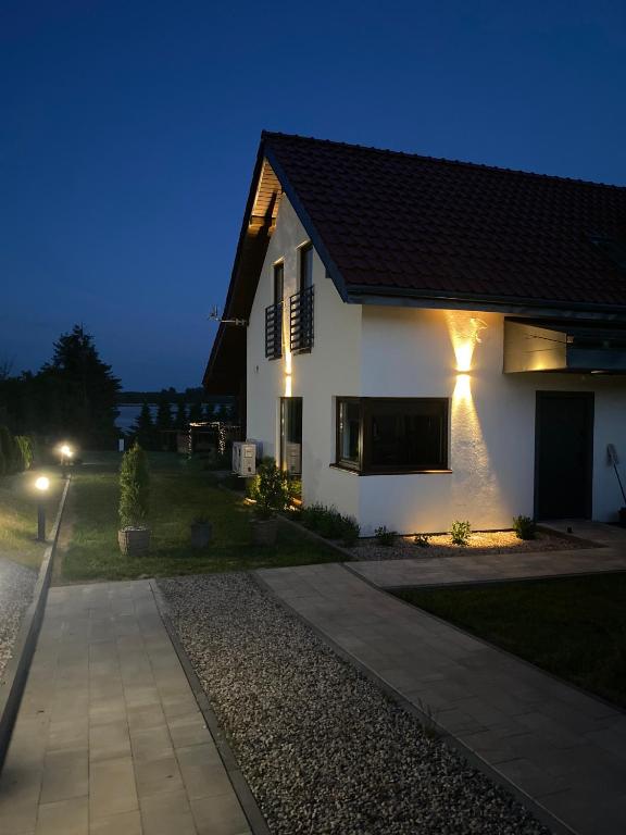 a white house at night with a driveway at Białe Żagle Mazury in Węgorzewo