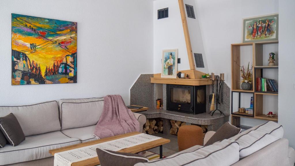 a living room with a couch and a fireplace at Kaba Home - Mountain Villa with Sauna in Stoykite