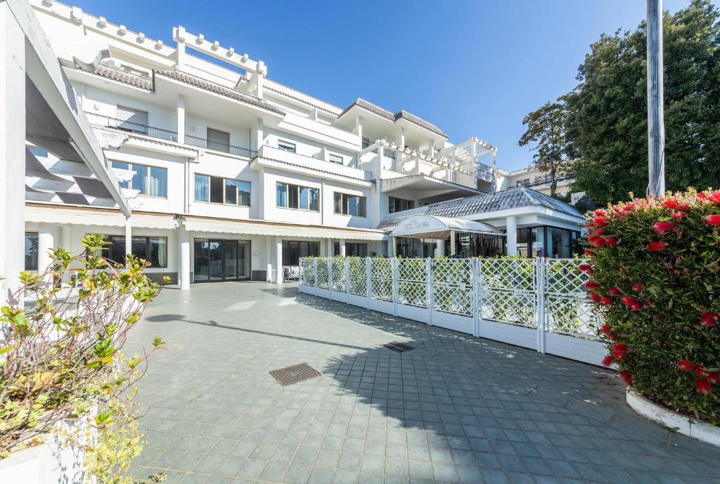 a white building with a fence and some flowers at Hotel Sakura, Sure Hotel Collection by Best Western in Torre del Greco