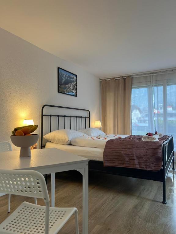 a bedroom with a bed and a table and a window at Harderkulm in Interlaken